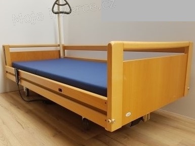 Elektricky polohovatelná postel s hrazdičkou.